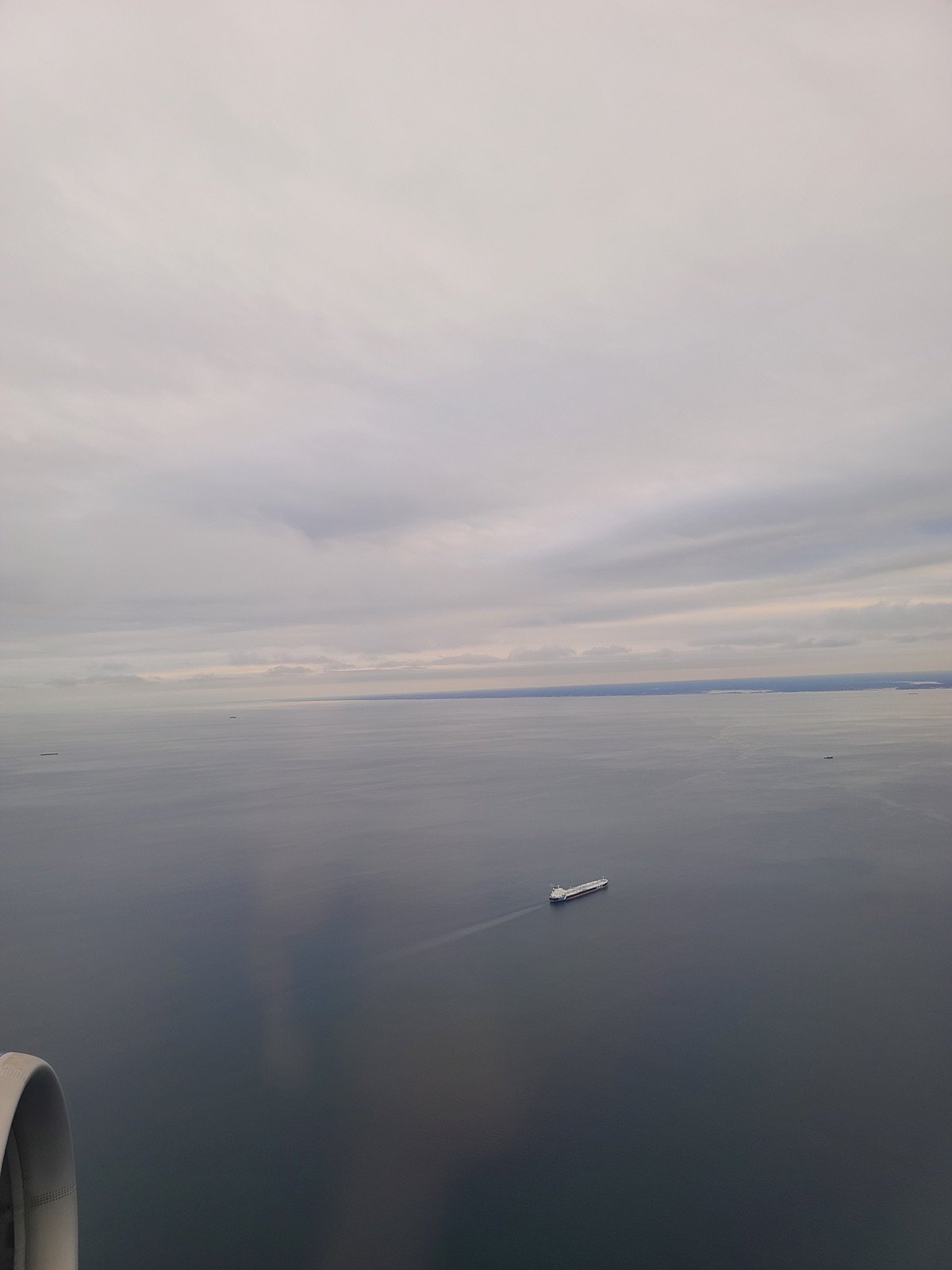 Aerial view over open water from a plane window