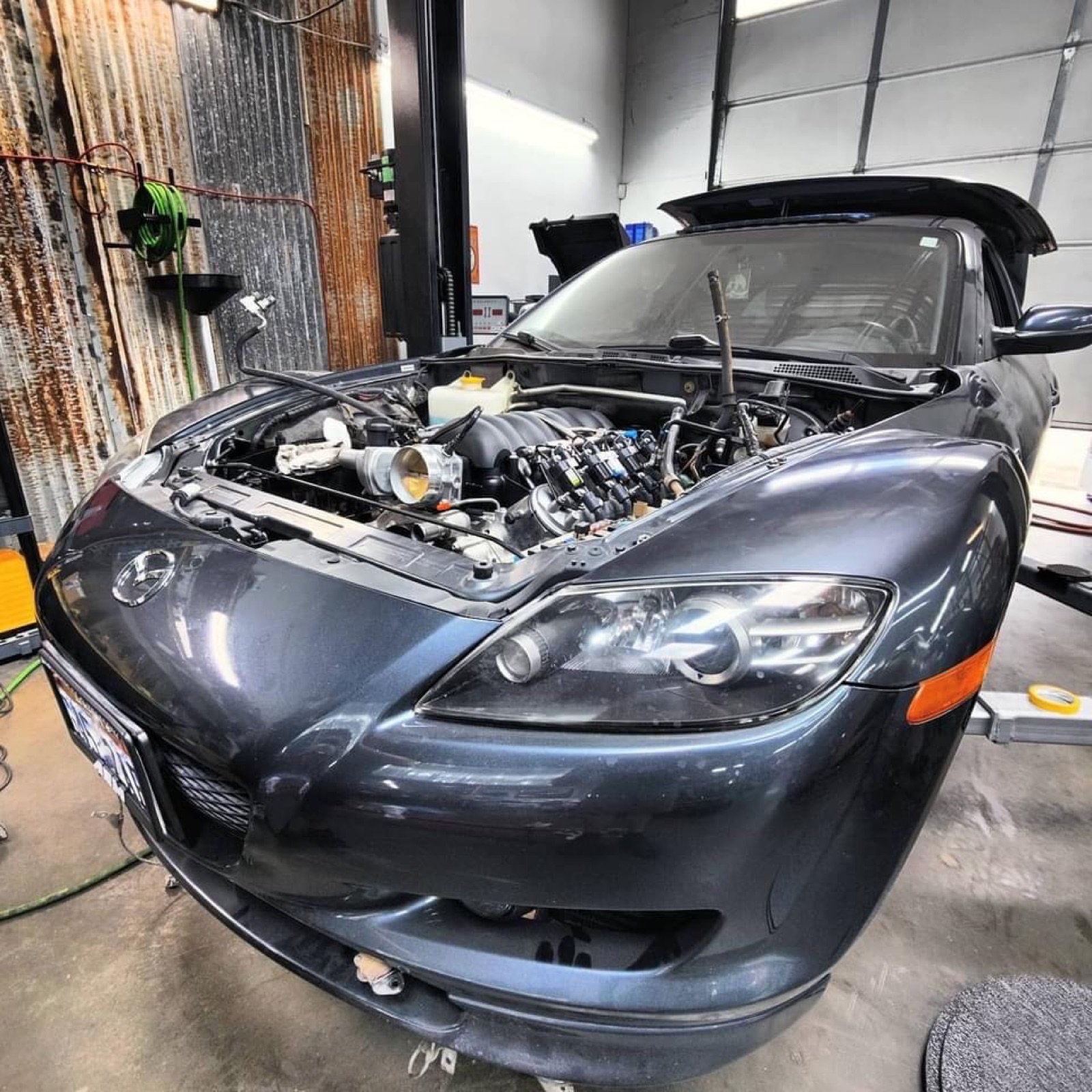 Mazda RX8 in the shop, hood up, mid-build